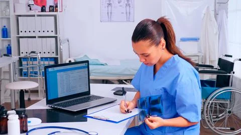 Nurse checking x-ray result, reading patients list Stock Photos