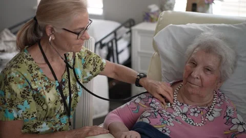 Nurse Checks Vitals While Chatting With Senior Woman at Care Center Stock Footage 313488773