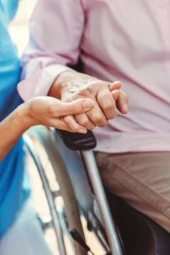 Nurse consoling a senior woman in the nursing home holding her hand Stock Photos