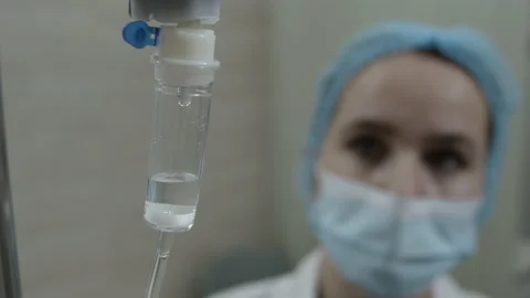 Nurse in defocus looks at a dropper Видео 135652679
