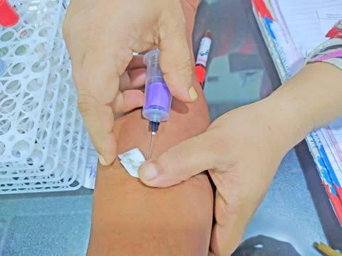 Nurse drill needle into a patient into vain to take for blood into syringe Stock Photos
