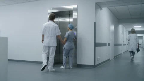 Nurse with elderly patient wait for elevator in medical center hallway Stock Footage 249791193
