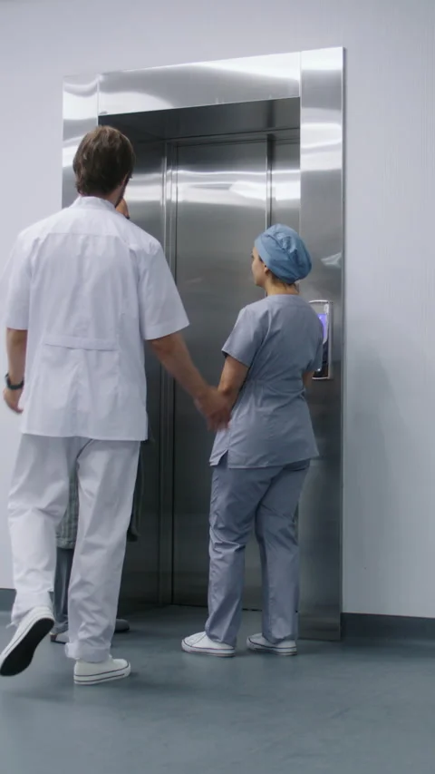 Nurse with elderly patient wait for elevator in medical center hallway Stock Footage 274902196