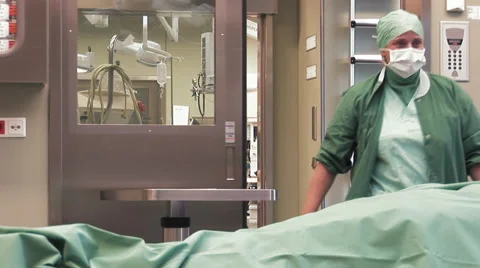Nurse enters operating room while patient lies on operating table Stock Footage 67276535