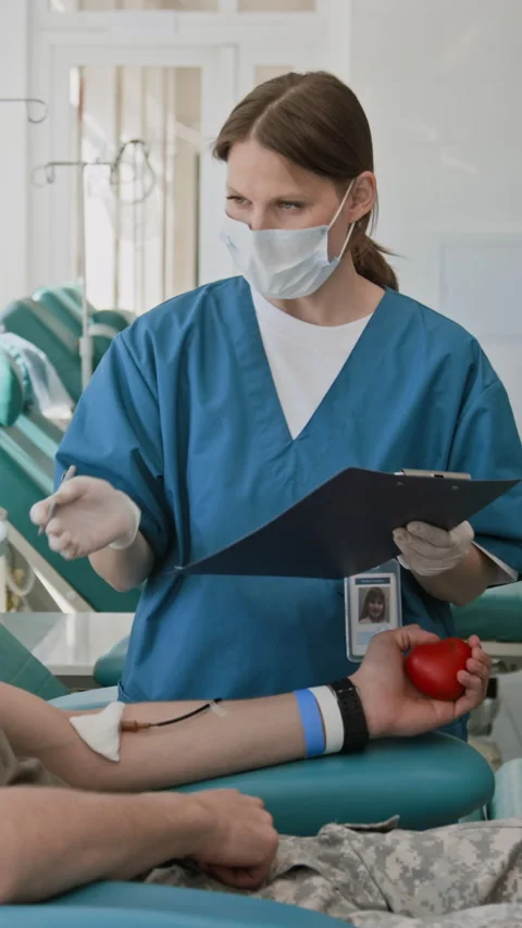 Nurse Filing Personal Documents of Unrecognizable Blood Donor in Clinic Stock Footage 317049813