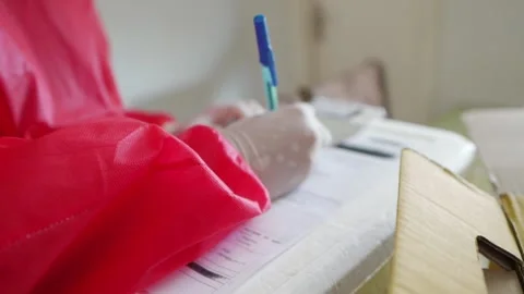 Nurse filling out document to perform corona virus test at patient's house Stock Footage 153345200