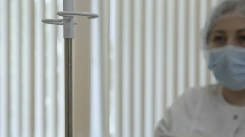 A nurse fixes a drip to a tripod Stock-Footage 92205143