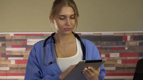 Nurse gets acquainted with the list of tasks in the hospital using ipad Stock Footage 75679405
