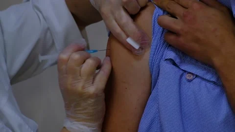 A nurse gives an injection to a man Stock Footage