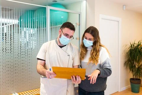 Nurse helping and explaining something to his patient who is being treated at Foto stock
