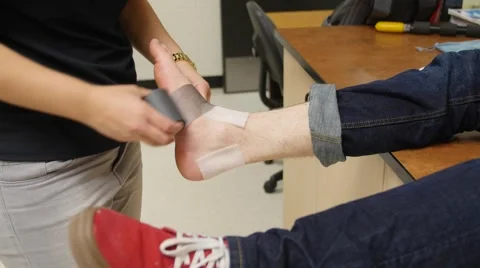 Nurse helping a boy with a sprained ankle Stock Footage 61689075