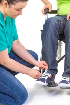 Nurse helping a disabled young man in wheelchair Stock Photos