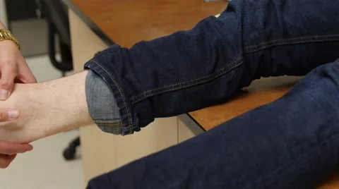 A nurse helps a boy with a sprained ankle Stock Footage 61682463