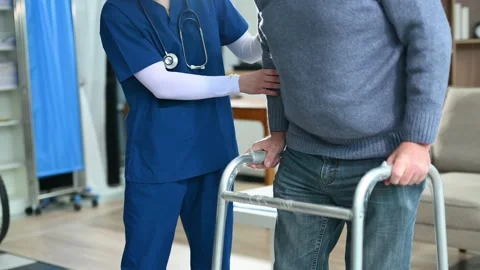 Nurse helps elderly man stand with walker during a home care session. Conce.. Stock Footage 316458772