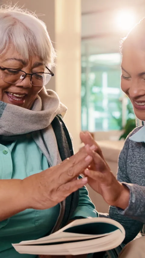 Nurse, high five and senior woman in home with book, word search and encourage Stock Footage 341482574