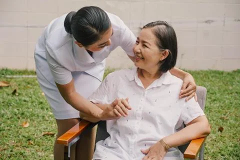 Nurse holding hands with supporting  an elderly woman  in a nursing house. Stock Photos