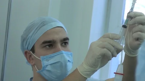 A nurse injects a syringe. dropper with anesthesia dripping. closeup Video stock 125817853