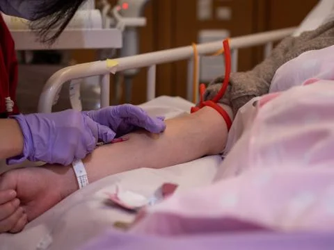 A nurse inserting a canula into a patient's arm Foto stock