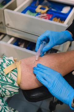 Nurse Inserting Needle into Patient Arm for Blood Collection. Stock Photos