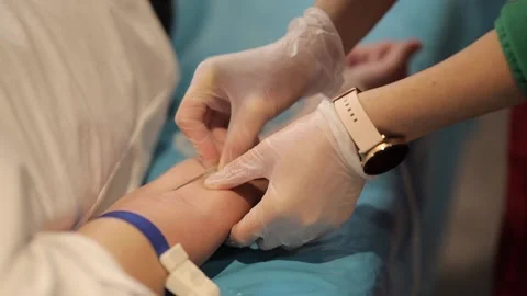 The nurse inserts a needle into the patient's arm. Blood donation concept. Stock Footage 230131203
