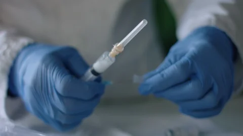 Nurse inserts syringe needle for injection Stockbeeldmateriaal 102051727