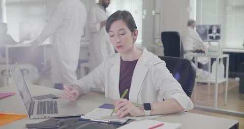Nurse making work schedule for chief doctor on laptop and write on paper Stock Footage 93877724