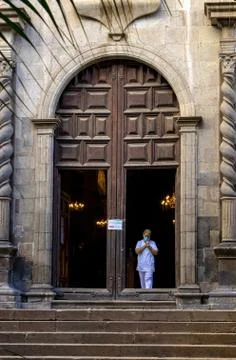 Nurse / medic with face medical mask exiting from a church after she pray Stock Photos