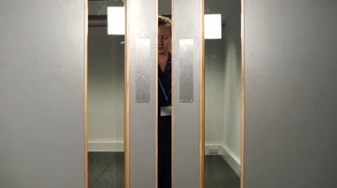 Nurse opens and walks through hospital doors straight to camera Stock Footage 59087346