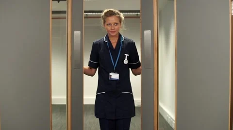 Nurse opens hospital doors takes a deep breath and walks straight to camera Vídeos de archivo 59087348