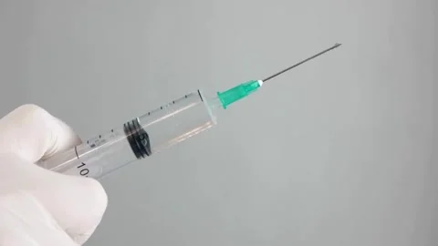 Nurse prepares a syringe for an injection Medium closeup studio shot of a young Stock-Footage 336587445