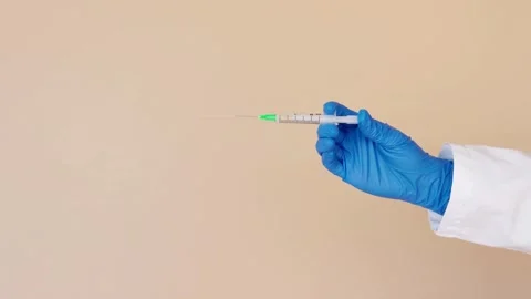 Nurse prepares a syringe for an injection Medium closeup studio shot of a young Stock-Footage 336587528
