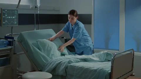 Nurse preparing bed and blanket in hospital ward 스톡 동영상 157057769