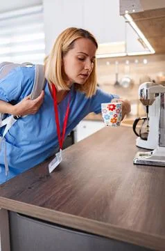 Nurse preparing for work drinking coffee in the kitchen Foto stock