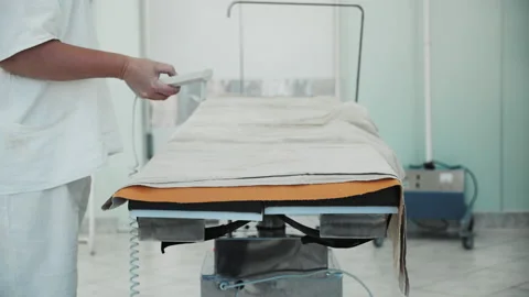 Nurse pressing buttons on remote control, surgical operating table rotating Video stock 201513278