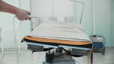 Nurse pressing buttons on remote control, surgical operating table rotating Video stock 201524569