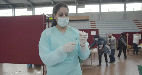 Nurse in protective suit preparing vaccine dose flu shot coronavirus vaccination Stock Footage