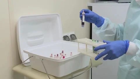 A nurse in protective suit puts the samples in a protective box Stock Footage 132318591