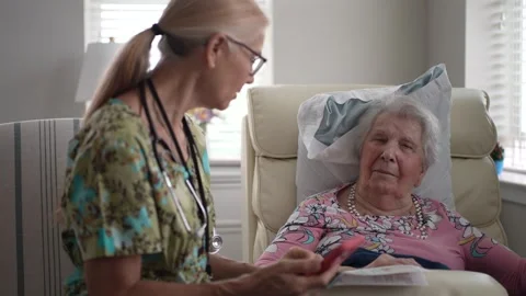 Nurse Provides Caring Support to Senior Woman During Health Check in Facility Stock Footage 313348438