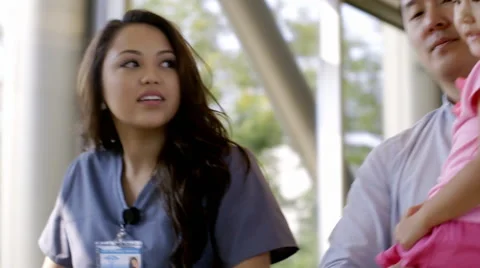 Nurse pushing mother of newborn baby in corridor with family Stock Footage 67176148