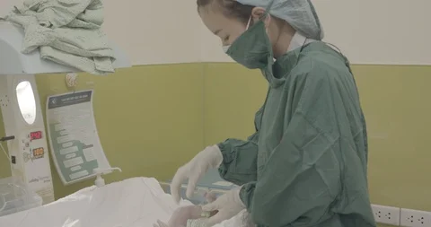 Nurse put on the tag on newborn crying baby leg Stock Footage 127754829