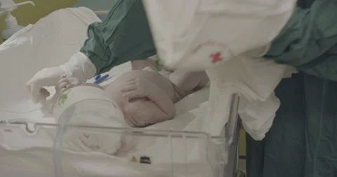 Nurse put on white blanket under newborn crying baby Stock Footage 127754850