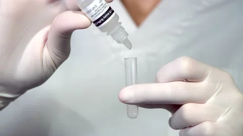 A nurse puts drops from the serological bottle for a covid-19 antigen test Stock Footage