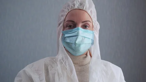 The nurse puts on a protective suit. Video stock 128254526