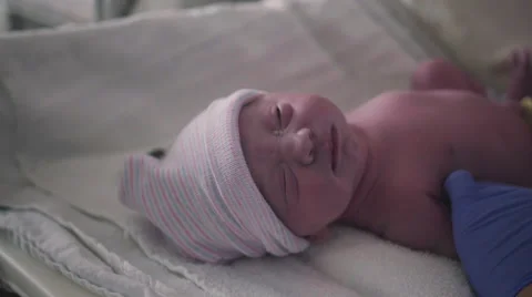 Nurse Puts Stocking Hat on Newborn Baby Girl Just Born in Hospital Stock Footage