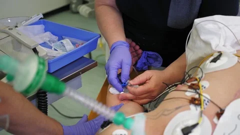 Nurse putting a drip into the catheter lying patients Stock Footage 84615100