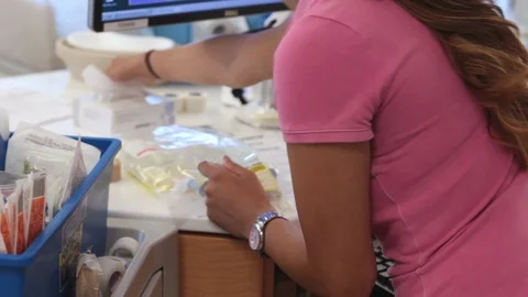 Nurse reaches for documents while handling IV drip bags Stock Footage 127850182