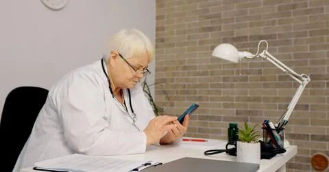 Nurse scrolling on smartphone using technology Stock Photos