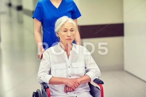 Nurse with senior woman in wheelchair at hospital Stock Photos