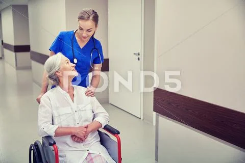 Nurse with senior woman in wheelchair at hospital Stock Photos