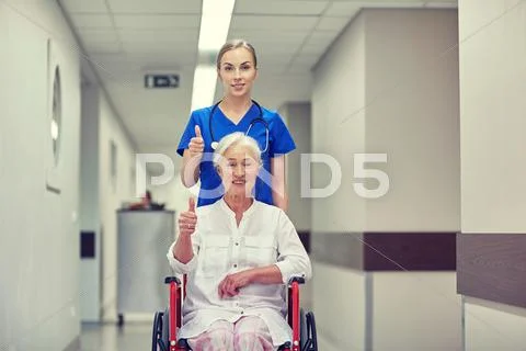 Nurse with senior woman in wheelchair at hospital Stock Photos